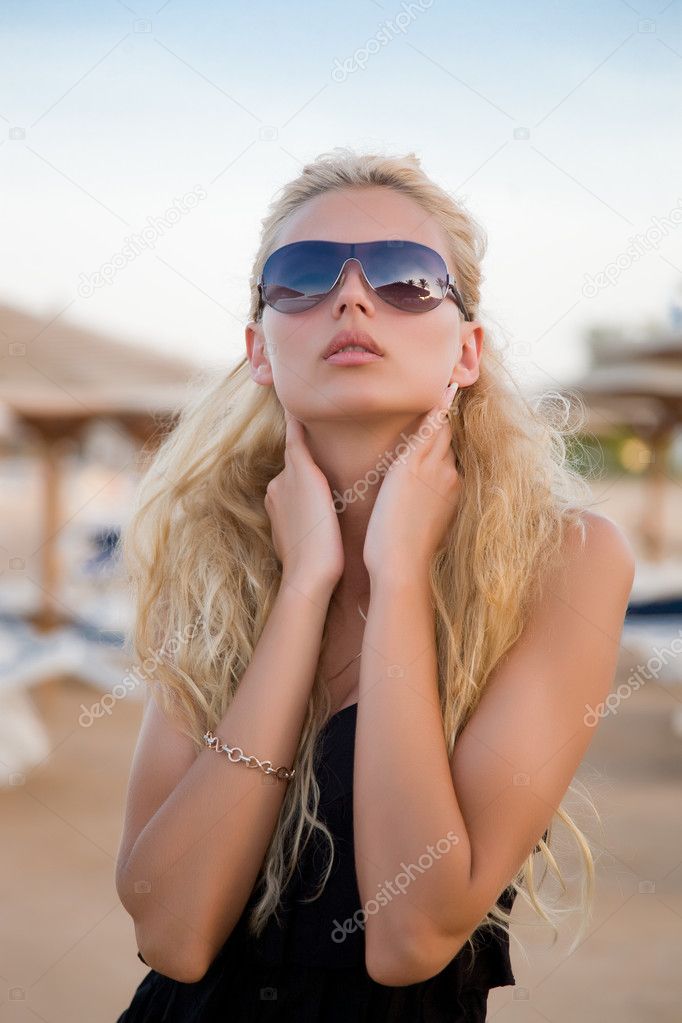 Sexy blond girl with glasses on a beach