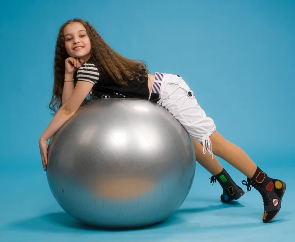 Молода дівчина лежить на великому гумовому м'ячі — стокове фото