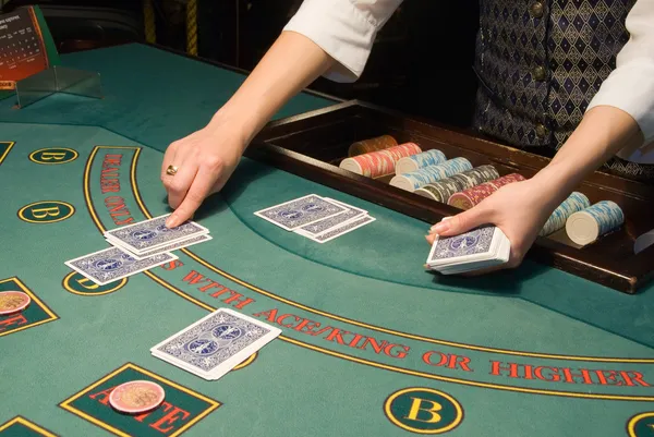 Croupier manipulant des cartes à la table de poker — Photo