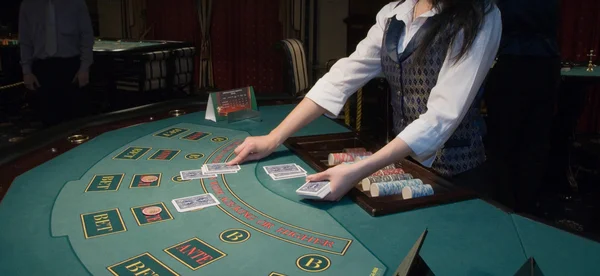 Croupier handling cards at poker table — Stock Photo, Image