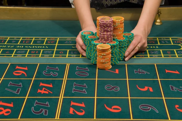 Distribuidor de Casino manejando una pila de fichas — Foto de Stock