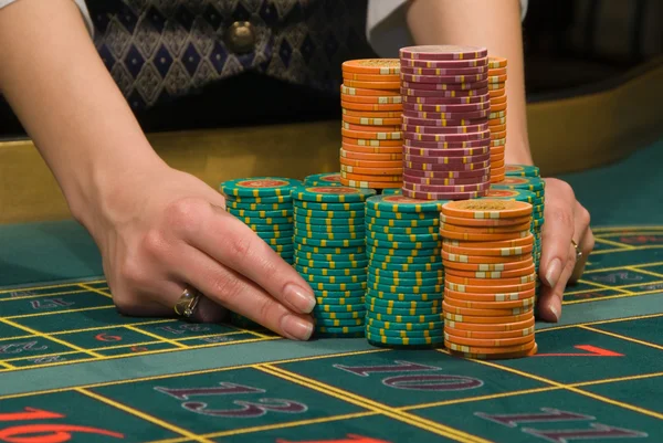 Casino Dealer, der mit einem Haufen Chips hantiert — Stockfoto
