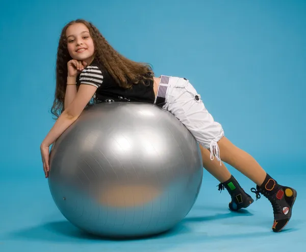 Young girl lying on a big rubber ball Stock Picture