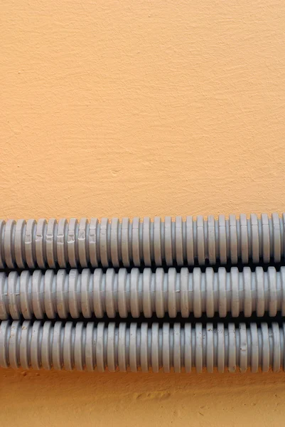 Potrójne gniazdo szary kabel na ścianie krem — Zdjęcie stockowe