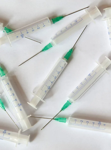 Injekční stříkačky s jehlami na bílém pozadí — Stock fotografie
