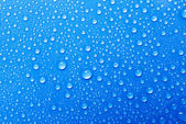 kapky vody na modré sklo