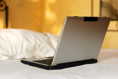 açık bir yatağın üstünde laptop