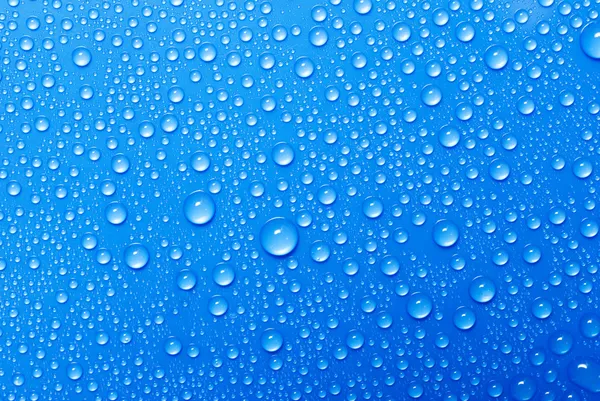 Капли воды на голубой стакан — стоковое фото