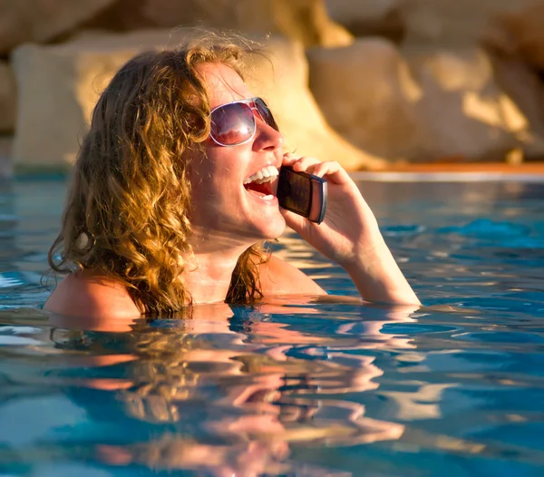 Разговор по телефону в бассейне — стоковое фото