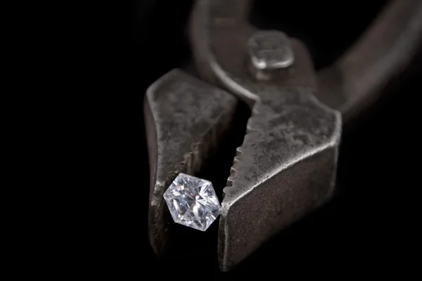 Vintage pliers hold a gem diamond — Stock Photo, Image
