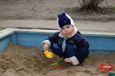 The child, playing to a sandbox clipart