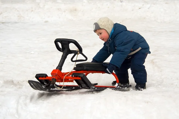 The child pushes sledge — Stock Photo, Image