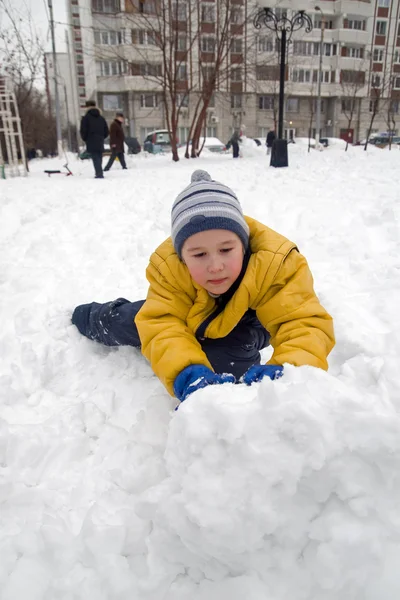 The boy rolls snow whom — Stock Photo, Image