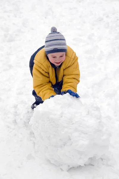 The boy rolls snow whom — Stock Photo, Image