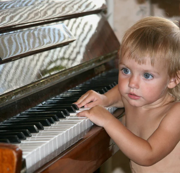 Den lilla flickan och piano — Stockfoto