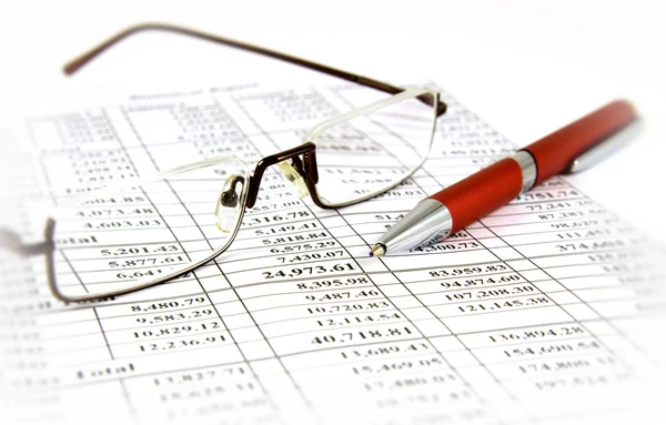 Finanzbericht mit Stift und Brille lizenzfreie Stockbilder
