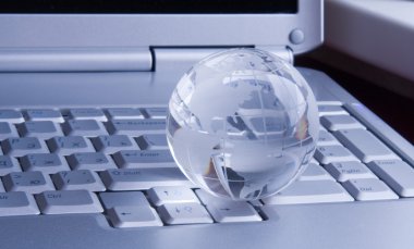 Globe on keyboard of modern notebook clipart