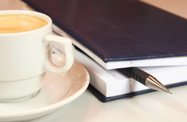 Біла чашка кави та щоденника — стокове фото