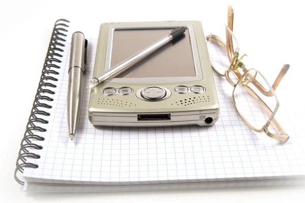 Pen, PDA and eyeglasses on notebook — Stock Photo, Image
