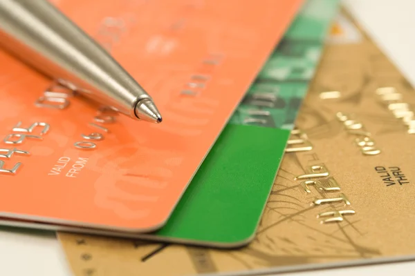 Pluma, tarjetas de crédito, billetes y monedas — Foto de Stock