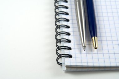 Two pens on spiral notebook with copyspa clipart
