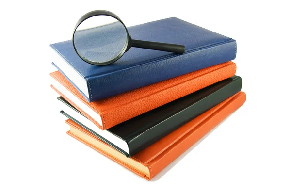 Magnifying glass on stack of books — Stock Photo, Image
