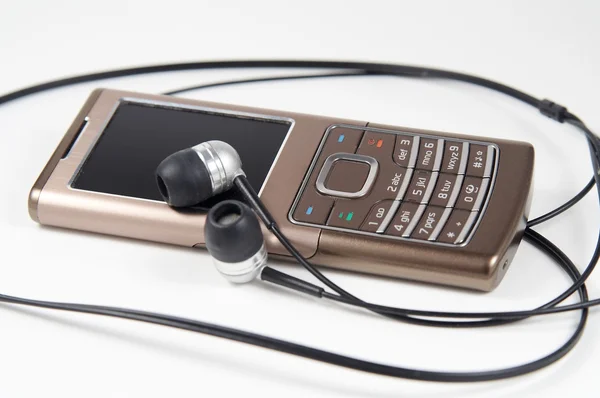 Moderno telefone celular fino com fones de ouvido — Fotografia de Stock