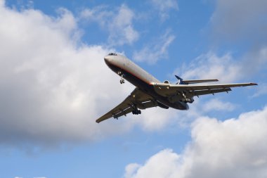 Passenger airplane landing on blue sky w clipart