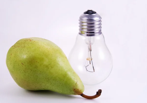 Green pear and electric bulb on white — Stock Photo, Image
