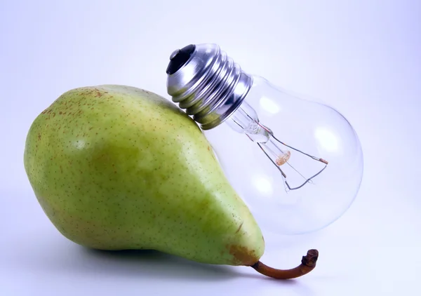 Green pear and electric bulb — Stock Photo, Image