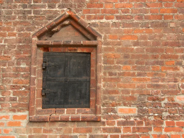 Okno s kovové závěrky ve staré červené bri — Stock fotografie