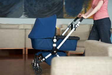 Woman indoor with a stroller clipart