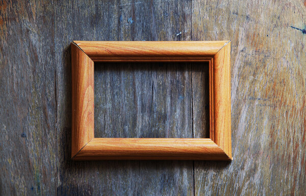 Empty photo-frame on wooden background