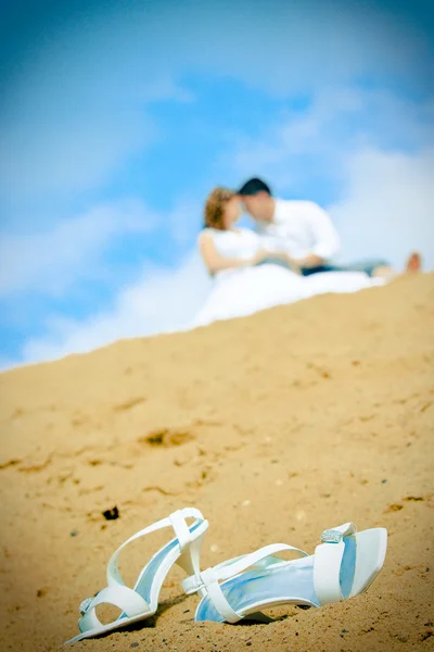 Bride shoes and newly married couple — Stock Photo, Image