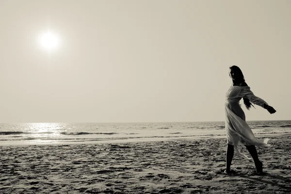 Junge Frau spaziert am Strand lizenzfreie Stockfotos