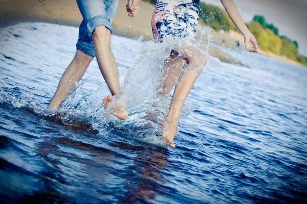 Plajda sıçramasına Çift — Stok fotoğraf