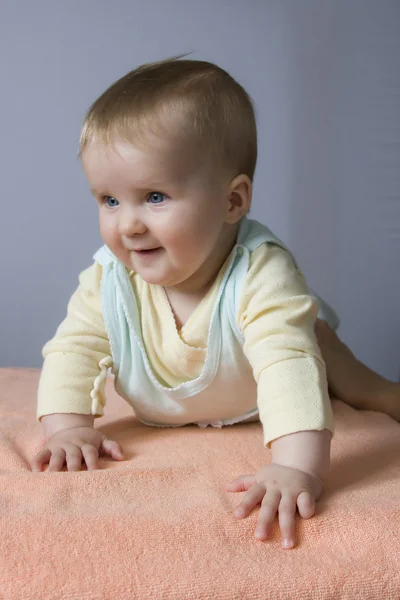 Baby lügt und lächelt lizenzfreie Stockfotos