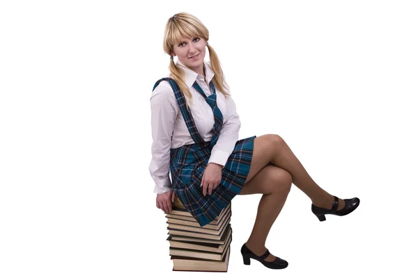 Schoolgirl is sitting on the stack of bo Stock Photo