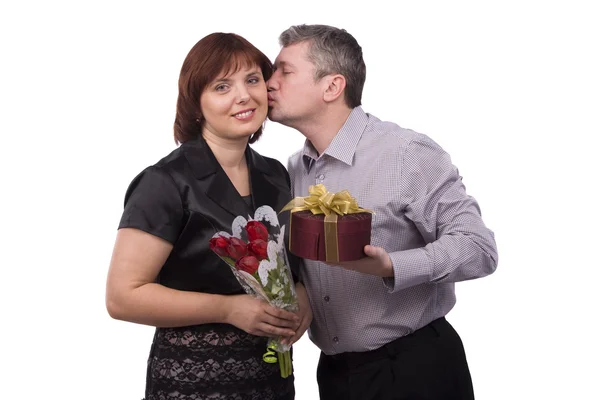 Мужчина дарит подарок и целует женщину — стоковое фото