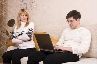 Woman angry with man for working laptop clipart