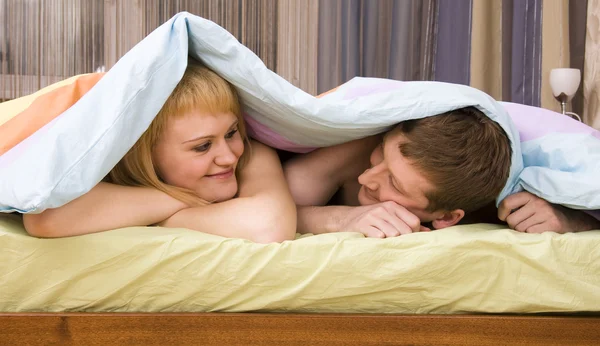 Casal feliz brincando na cama — Fotografia de Stock