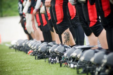 Row of football helmets and feet clipart