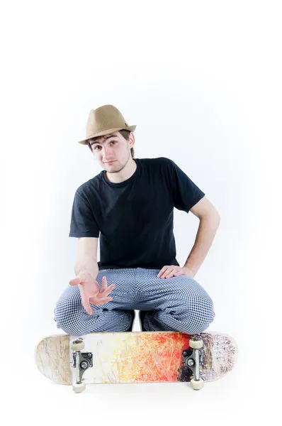 Серьезный подросток, сидящий на коньках — стоковое фото