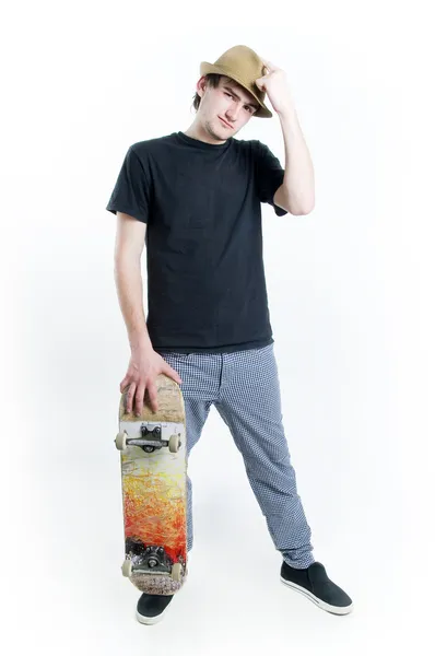 Серьезный подросток со скейтом — стоковое фото
