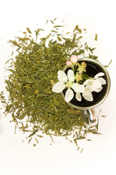 stock image Cup of tea with flower and tea leafs