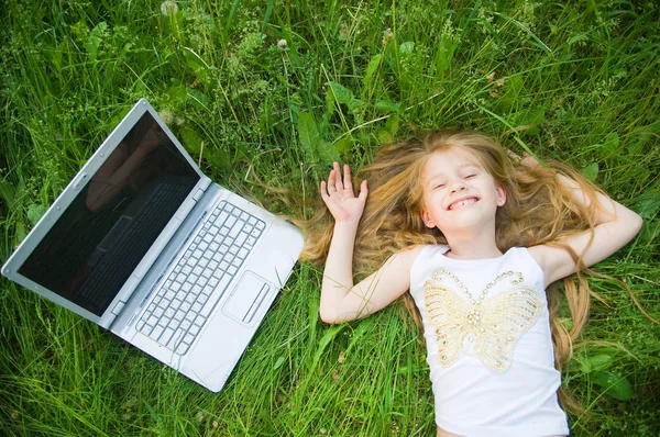 Забавная маленькая девочка с ноутбуком — стоковое фото