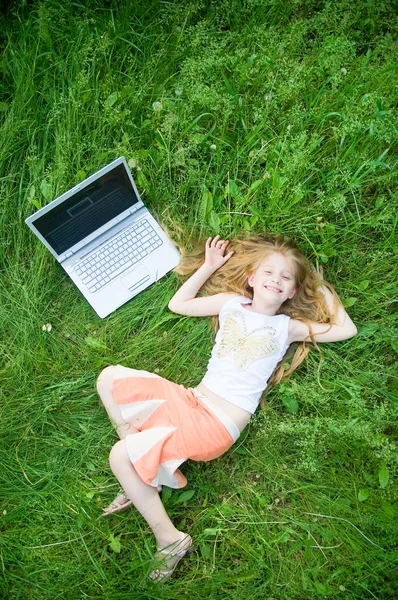 Забавная маленькая девочка с ноутбуком снаружи — стоковое фото