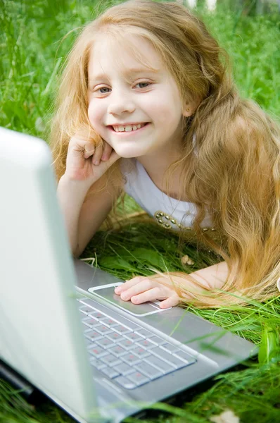 Dizüstü bilgisayar ile küçük kız gülümseyerek — Stok fotoğraf