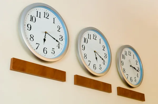 Rad av klockor med olika tid — Stockfoto