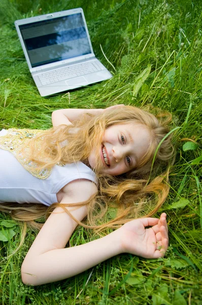 Lustiges kleines Mädchen mit Laptop draußen — Stockfoto
